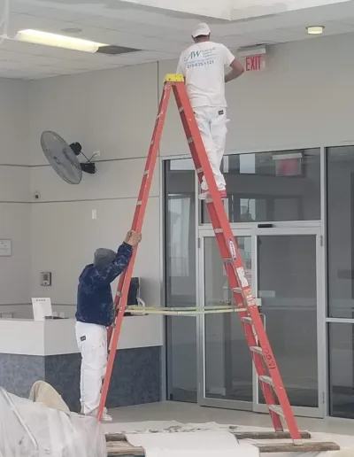 AW Painting & General Contractors, Inc. workers painting the interior of a commercial building.